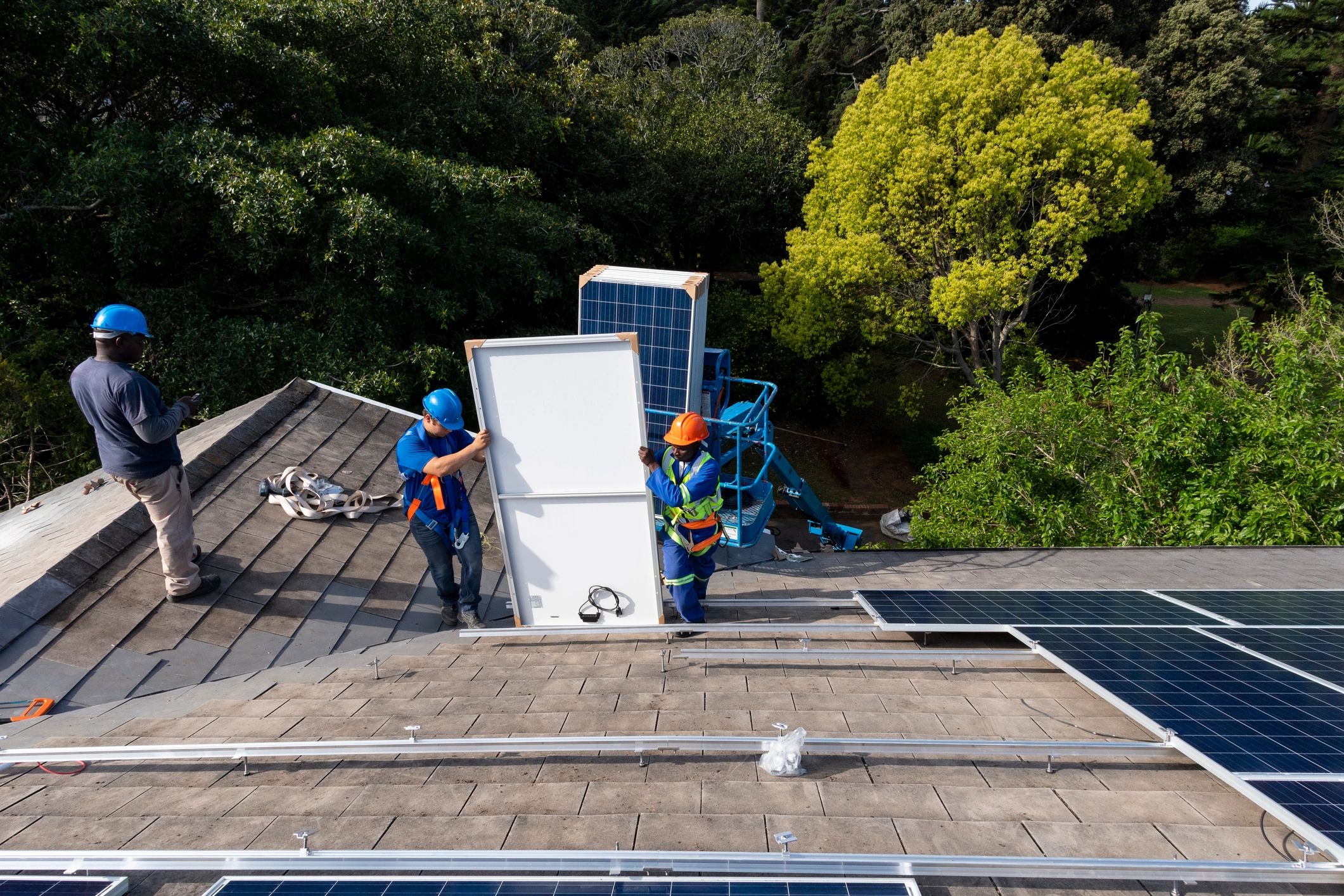 Engineering team installing solar panels on an industrial roof