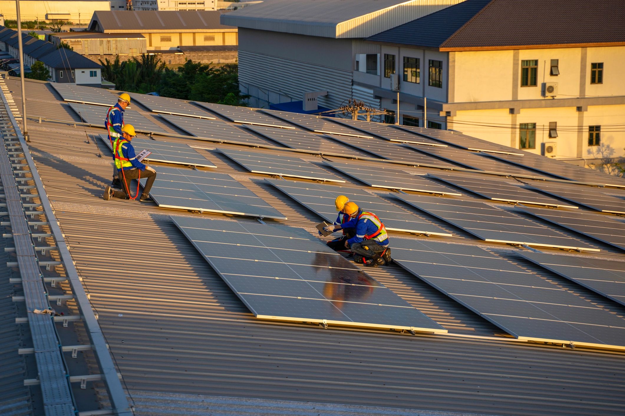 Workers on a factory rooftop solar installation